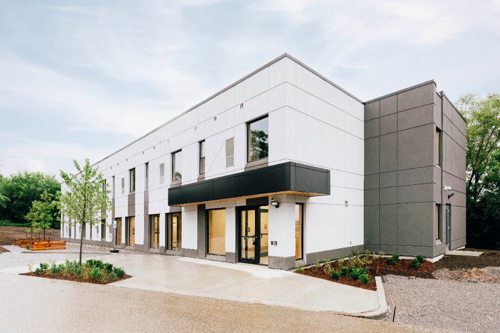 Completed two-storey building with landscaping and a glass entrance