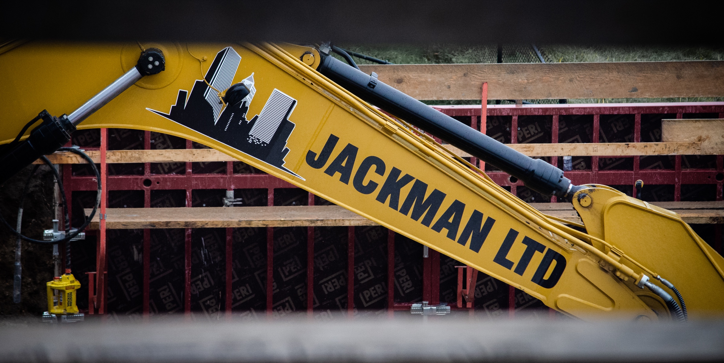 Jackman Ltd. excavator arm with company branding on a job site
