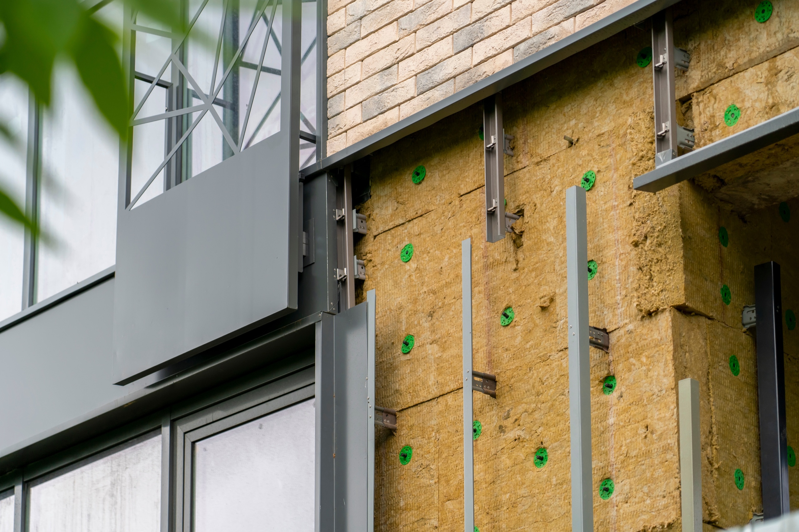 Mineral wool exterior insulation installed behind a commercial cladding system