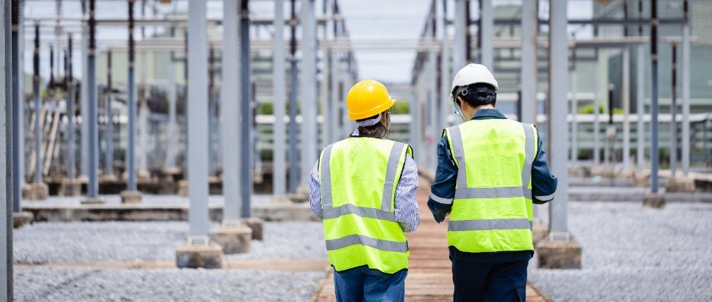 Two workers in high-visibility vests walking a site inspection